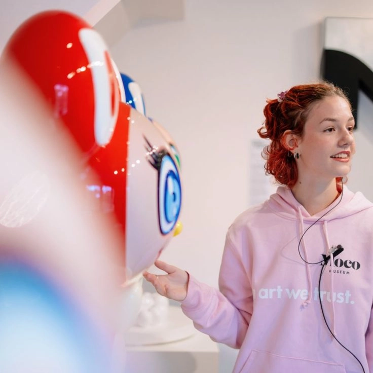 Crew interacting with colorful sculpture at Moco Museum Amsterdam.