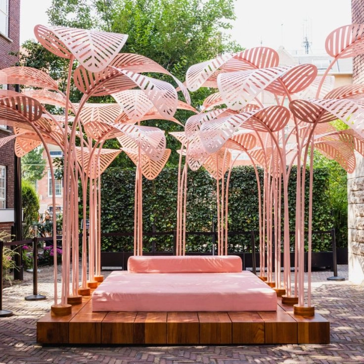 Pink outdoor art installation with umbrella-like structures at museum Amsterdam.